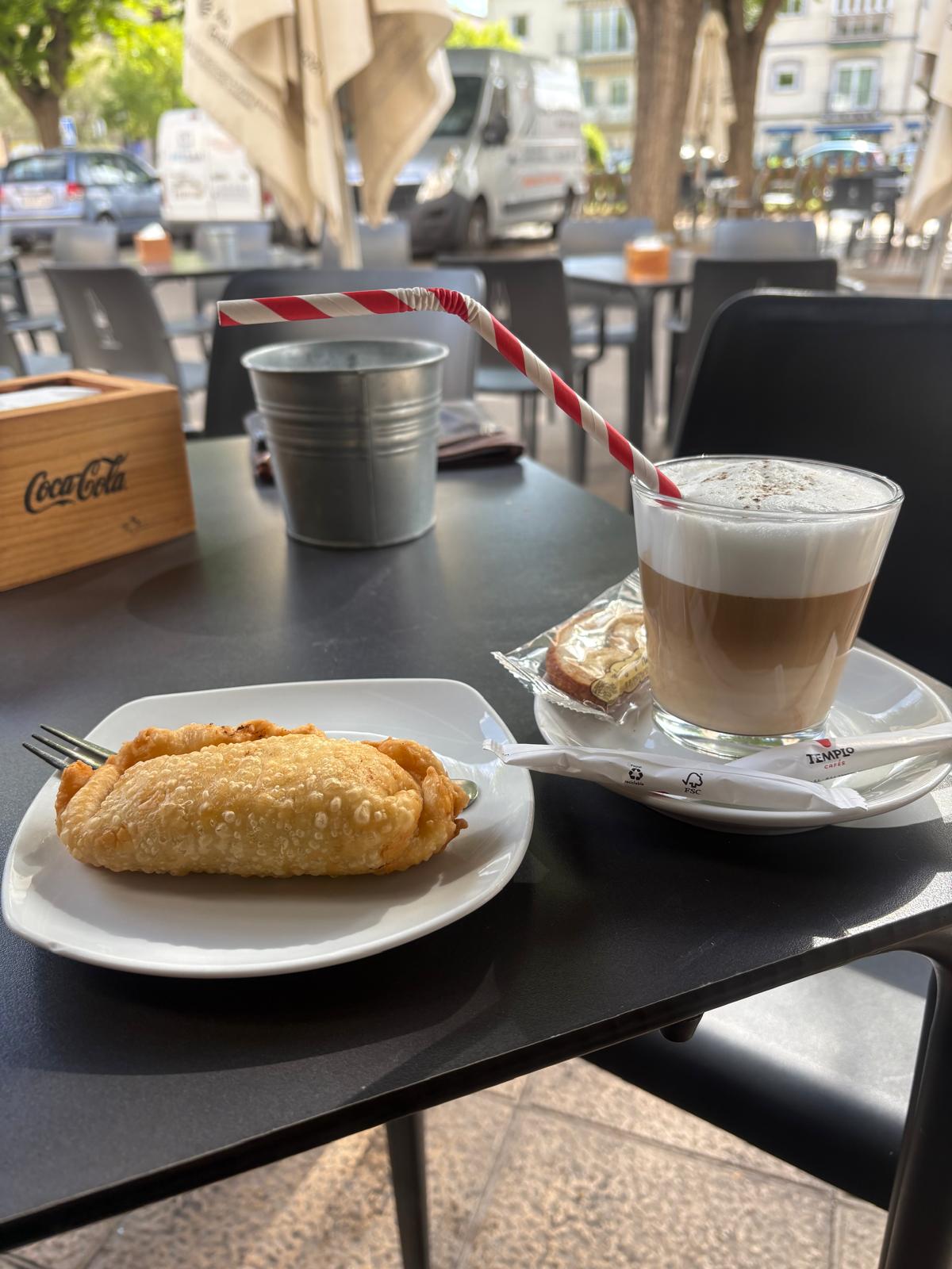 Desayuno con empanadilla y café con leche en la terraza